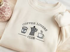 Embroidered Coffee Lovers Sweatshirt Stay cozy and fun with our uniquely embroidered sweatshirt! Made with love and THOUSANDS of threads! -Unisex Size (Please see the size chart for more details that can be found in the photos section)  We recommend comparing your favorite sweatshirt to our size chart to find the best size for you! Unisex Crewneck -50% cotton 50% polyester -Super soft -Pre-shrunk -Unisex -Design size is 3''-4"  Thread: We use the best quality threads for our embroidery designs. Coffee Related Gifts, Embroidery Designs Sweater, Custom Sweatshirt Ideas, Cozy Girl Aesthetic, Embroidery Hoodies, Coffee Embroidery, Aesthetic Embroidery, Mom Embroidery, Embroidered Tee Shirt