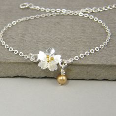 This dainty silver flower bracelet is perfect for layering or to wear on its own. Either way, this silver and gold flower bracelet makes a lovely gift for girls or for women with small wrists. Give your mom, daughter, or friend the gift of sterling silver jewelry they'll love and enjoy wearing. Featuring a sterling silver bracelet chain and dimensional flower with gold plated stamen. Personalized with a small Swarovski crystal pearl accent bead in your choice of colors. Bracelet is small - 6 3/4 Dainty Silver Charm Bracelet For Bridesmaid Gift, Delicate Sterling Silver Flower Bracelets, Delicate Sterling Silver Flower Bracelet, Delicate Flower-shaped Sterling Silver Bracelets, Delicate Silver Flower Bracelets, Delicate Silver Flower Bracelet, Dainty Silver Flower Bracelets, Dainty Silver Flower Charm Bracelet, Delicate Silver Bracelets With Flower Charm