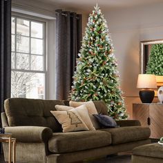 a living room filled with furniture and a christmas tree in front of a large window