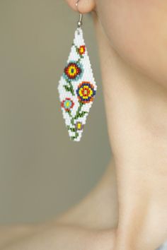 a close up of a person wearing some kind of earring with flowers on it