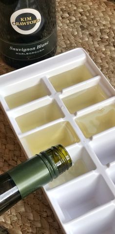 a bottle of olive oil sitting on top of an ice tray