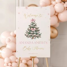 a welcome sign for a baby shower with balloons in the background and a christmas tree on it