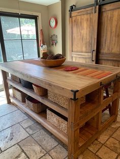 a kitchen island made out of wood with baskets on the top and drawers below it