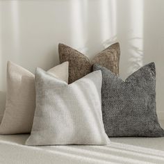 four pillows sitting on top of a white couch