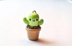 a small green cactus in a clay pot with its eyes closed, sitting on a white surface