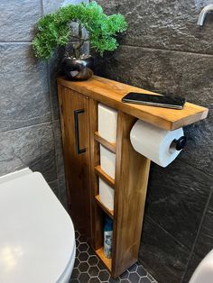 a bathroom with a toilet, sink and wooden cabinet next to the toilet paper roll dispenser