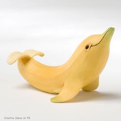 a banana with a face drawn on it sitting next to a white wall and floor