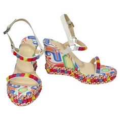 Introducing the Christian Louboutin Multicolor Printed Stud Wedges - a kaleidoscope of style, creativity, and playful charm. These wedges are the epitome of eye-catching, vibrant fashion that's perfect for those who appreciate a bold and unique statement piece. The standout feature of these wedges is the whimsical printed patent leather. The geometric shapes and patterns adorning the wedge create an intriguing and lively design that's bound to turn heads. Each step you take will be a work of art Multicolor Open Toe Modern Heels, Modern Multicolor Open Toe Heels, Luxury Multicolor Sandals For Spring, Luxury Multicolor Heels For Summer, Luxury Multicolor Summer Heels, Luxury Multicolor Open Toe Sandals, Designer Multicolor Sandals, Modern Multicolor Sandals With Round Toe, Bold Multicolor Sandals For Spring