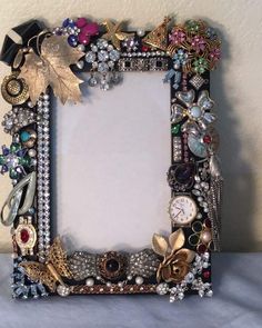 an ornate photo frame is adorned with jewels and other jeweled items, including leaves