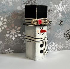 a wooden block with a snowman wearing a top hat and scarf