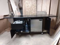 a kitchen island with two sinks and an open cabinet in the middle is being worked on