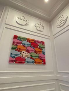 there is a colorful painting on the wall in this room with white walls and ceiling