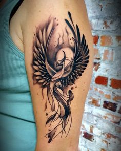 a woman's arm with a tattoo on it and a bird flying over her shoulder