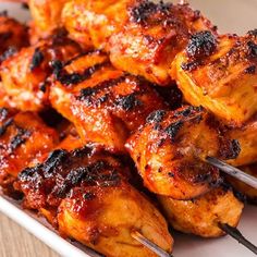 chicken skewers with toothpicks on a white plate