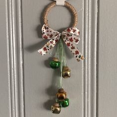 a door hanger with bells hanging from it's side and a bow on top