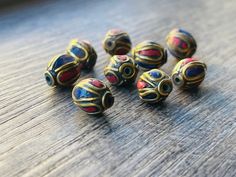 several colorful beads sitting on top of a wooden table