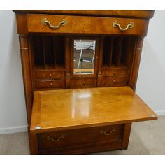 a wooden desk with drawers and mirror on top