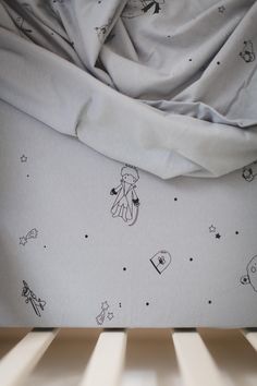 an unmade crib with some drawings on it