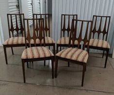 six chairs with striped upholstered seats in front of a shipping container