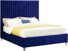 a bed with blue velvet headboard and white sheets