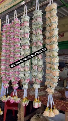 some kind of food hanging from the ceiling in front of a storefront with flowers on it