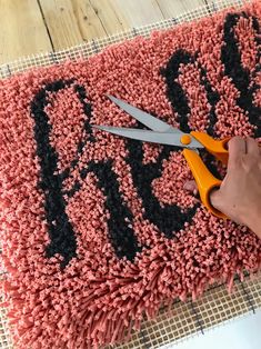 a pair of scissors are being used to decorate a rug with the word boo on it