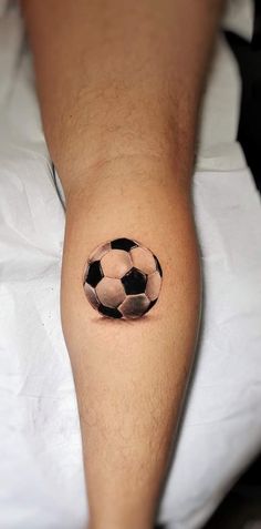 a man with a tattoo on his leg that has a soccer ball in the middle