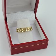 a gold ring in a red box on a white surface with the lid open to show it's inside