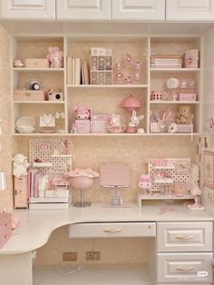 a white desk topped with lots of shelves filled with pink items and decorating supplies