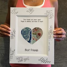 a woman holding up a framed poster with two heart shaped images in the middle and words written on it