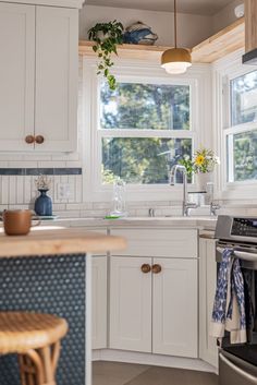 a kitchen with an oven, dishwasher, sink and window in the background