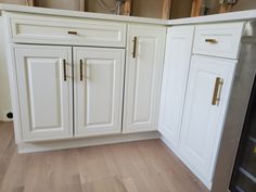 a kitchen with white cabinets and wood flooring in the middle of it's remodel