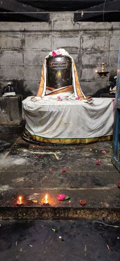 a shrine with candles and flowers on the ground