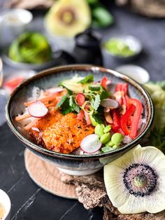 a bowl filled with food sitting on top of a table next to an onion wedge