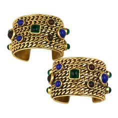 Extraordinary pair of Chanel chain decorated biker cuffs from the 1980's. Designed by Victoire de Castellane under Karl Lagerfeld, this is the period where all of Chanel's iconography was pumped up on on steroids. Incredibly constructed (and heavy!) bronze cuffs laden with chains and poured glass cabochons by Maison Gripoix in emerald, ruby and sapphire. Rare and exceptional find. 1980's France. Excellent condition. 1stdibs Jewelry, 1stdibs Chanel, Vintage Chanel Jewelry, Victoire De Castellane, Dope Jewelry Accessories, 90s Costume, Chanel Chain, The Crown Jewels, Chanel Collection