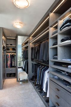 a walk in closet with lots of clothes