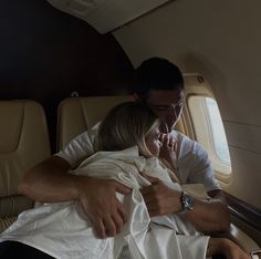 a man and woman are sitting in an airplane