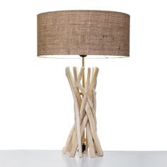 a table lamp made out of driftwood sticks on a white surface with a brown shade