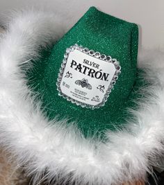 a close up of a green hat with white fur around it's neck and label on the front