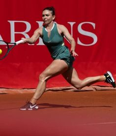 a woman is running to hit a tennis ball with her racket on the court