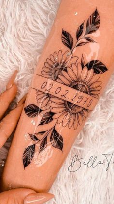 a woman's leg with tattoos and flowers on it