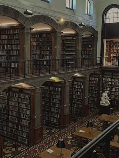 the interior of a library with many bookshelves and tables in front of them