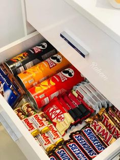 an open drawer filled with various snacks and candy bar flavors on top of each other