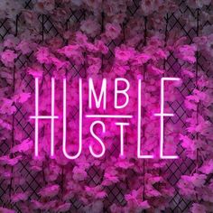 a neon sign that says humble hustle surrounded by pink flowers and lattices