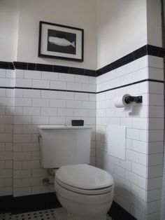 a white toilet sitting in a bathroom next to a black and white tile flooring