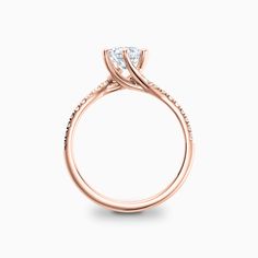 a rose gold engagement ring with a single diamond in the center and side stones on the band