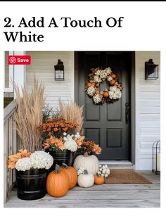 the front porch is decorated for fall with pumpkins and flowers in black buckets