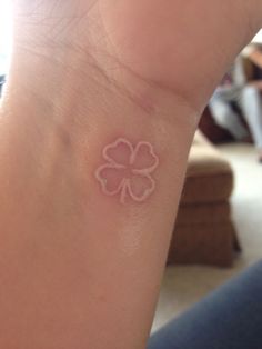 a small four leaf clover tattoo on the wrist