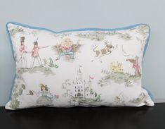 a pillow that is on top of a table with a castle and princesses on it