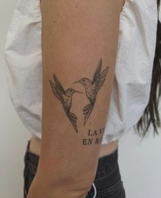 a woman with a tattoo on her arm that says la vie en maile and two birds